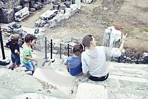 mother with little sons on vacation visiting ancient colosseum, summer tourism, lifestyle people concept