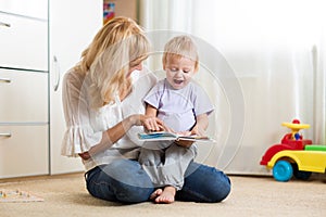 Mother looking at a book with her son at home