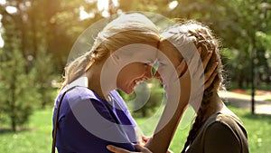 Mother looking at her pretty daughter with love and tenderness, awkward age