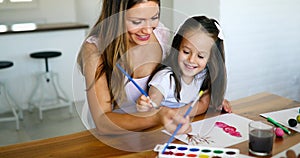 Mother looking how her child daughter drawing
