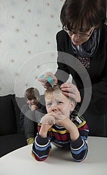 Mother looking for lice on youngsters head
