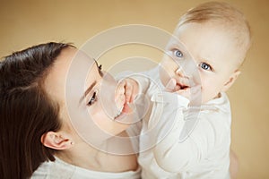 Mother looks at child with care love, baby on arms