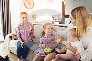 Mother with Lovely Kids Sits on Couch near Nanny photo