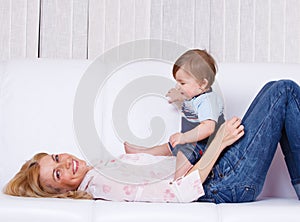 Mother lying playing with baby son