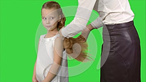 Mother makes daughter hairstyle on a Green Screen, Chroma Key