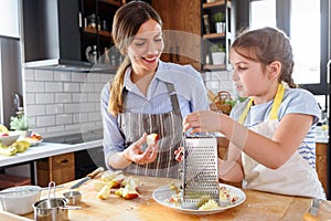 Mother making apple pie with children at home kitchen