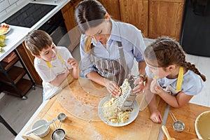 Mother making apple pie with children at home kitchen