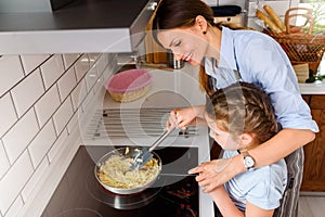 Mother making apple pie with children at home kitchen
