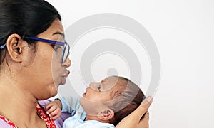A mother making funny face at her baby  in white background with space for text