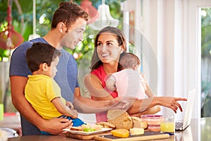 Mother Making Snack For Family In Kitchen