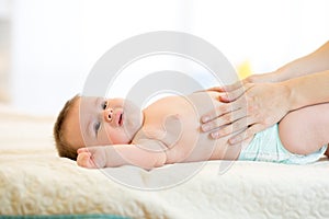 Mother massaging crying baby with colic