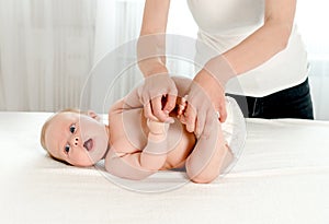 Mother massaging her infant baby