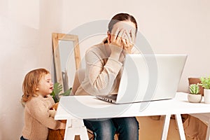 A mother on maternity leave sits at a laptop and works. A child yelling hysterically cries distracts from work. A woman is engaged