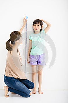 Mother measures the growth of her daughter photo