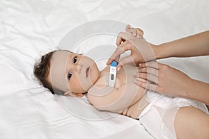 Mother measuring her baby`s temperature. Health care