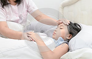 Mother measuring temperature of her ill kid.