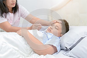 Mother measuring temperature of her ill kid.