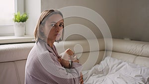 Mother measuring temperature of her ill kid at background. Sick child with high fever lying at sofa at home.