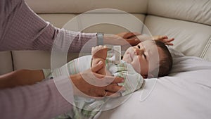 Mother measuring temperature of her ill kid at background. Sick child with high fever lying at sofa at home.