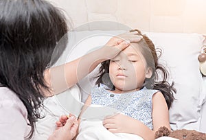 Mother measuring temperature of her ill kid by hand.