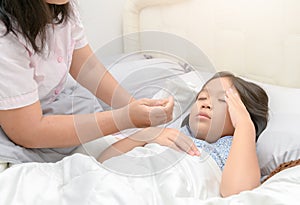 Mother measuring temperature of her ill kid.