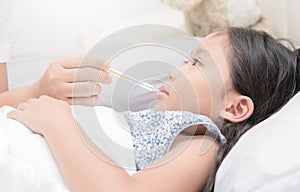 Mother measuring temperature of her ill kid