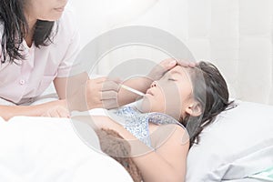 Mother measuring temperature of her ill kid.