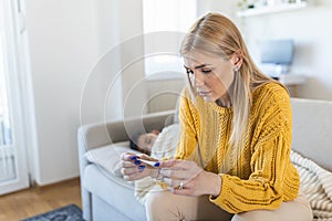 Mother measuring temperature of her ill kid. Sick child with high fever laying in bed and mother holding thermometer. Medicine and