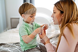 Mother measuring temperature of her ill kid. Sick child with high fever, mother holding thermometer.