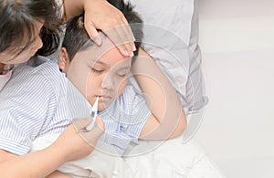 Mother measuring temperature of ill kid