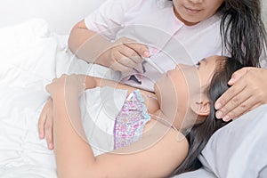 Mother measuring temperature of ill kid