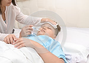 Mother measuring temperature of ill kid