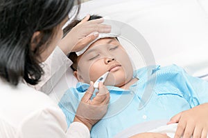 Mother measuring temperature of ill kid