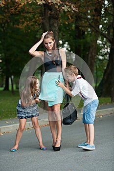 Mother with naughti son adn daughter on a walk in park photo
