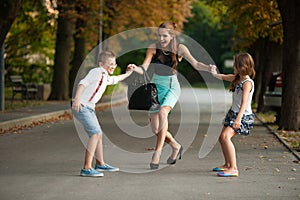 Mother with naughty son adn daughter on a walk in park