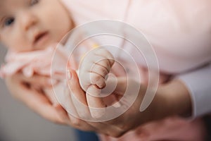 Mother with newborn baby hold hands closeup. Concept love and support of kid