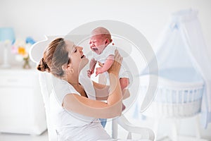 Mother and newborn baby in white nursery