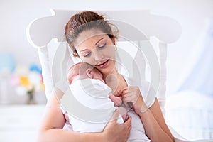 Mother and newborn baby in white nursery