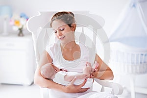 Mother and newborn baby in white nursery