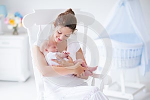 Mother and newborn baby in white nursery