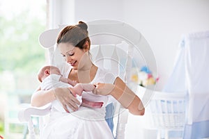 Mother and newborn baby in white nursery