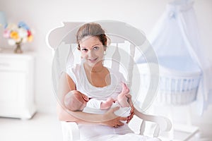 Mother and newborn baby in white nursery