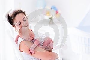 Mother and newborn baby in white nursery