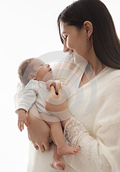 Mother with Newborn. Happy Mom hugging Baby. Happy Woman holding one Month little Child in Hands over White. Parent playing with