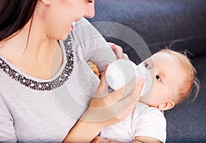 Mother nourishiing baby with milk bottle.