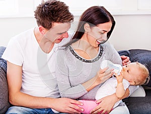 Mother nourishiing baby with milk bottle.