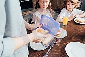 mother packing school lunch in box