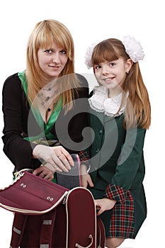 Mother is packing up backpack with daughter.