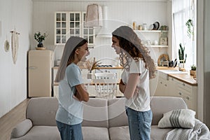 Mother parent having arguments with angry disrespectful teenage daughter at home photo