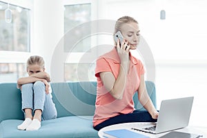 Mother is passionate about working on a laptop. Daughters do not have enough attention from mother.